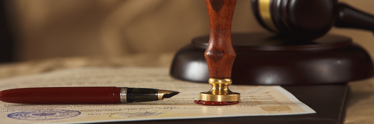 A picture of a legal scroll with fountain pen atop and stamper for a wax seal representing a probate query